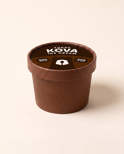 A single-serve cup of Kova fudge protein ice cream facing forward on a cream background