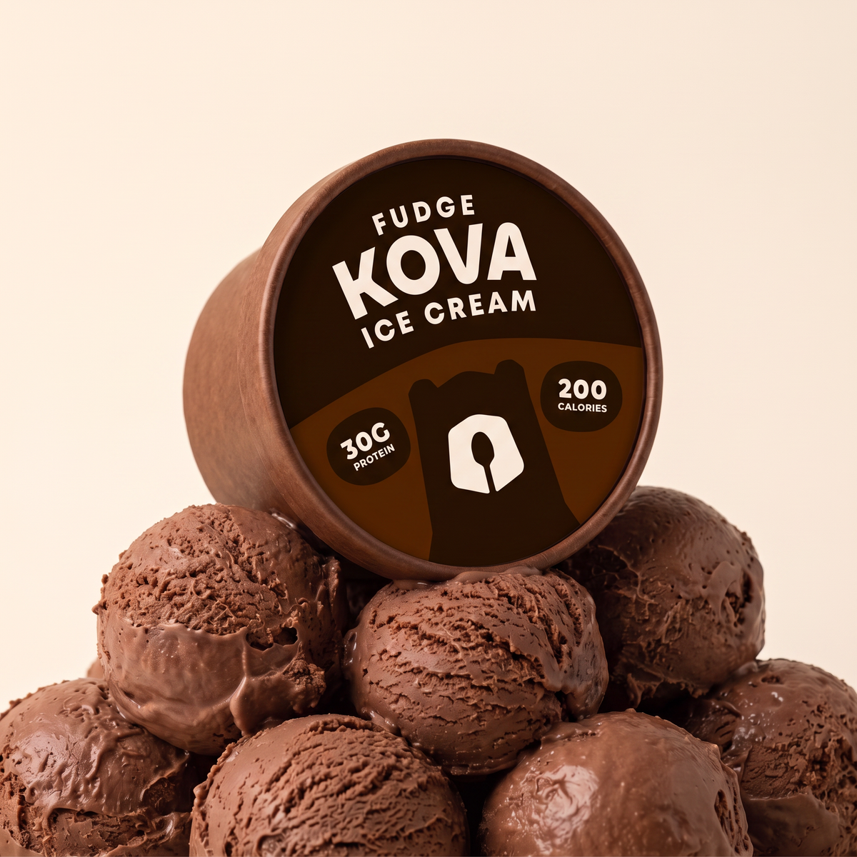 Kova Fudge protein ice cream cup resting on a mountain of chocolate fudge ice cream scoops — 30g protein, 200 calories
