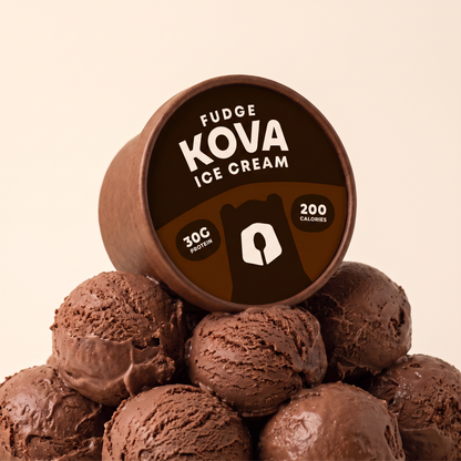 Kova Fudge protein ice cream cup resting on a mountain of chocolate fudge ice cream scoops — 30g protein, 200 calories